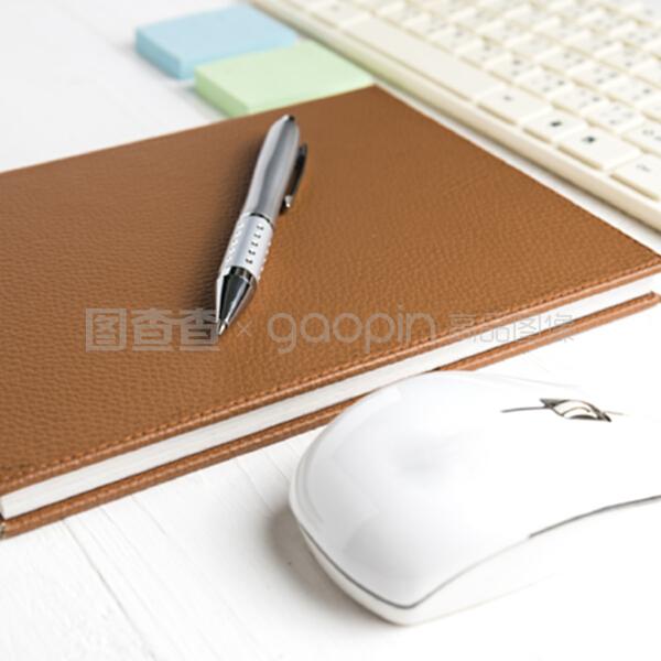 电脑和带办公用品的棕色笔记本